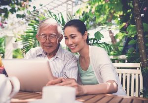 woman and elderly man on laptop