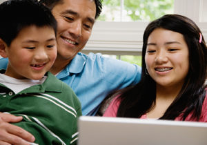 A happy family looks at a computer.