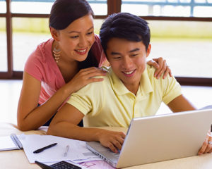 Smiling Couple Looking at Laptop