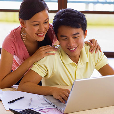 Smiling Couple Looking at Laptop