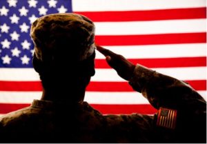 silhouette of a soldier standing in front of the american flag and saluting,  