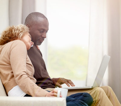 a couple sitting together on a sofa looking at their mySocialSecurity account