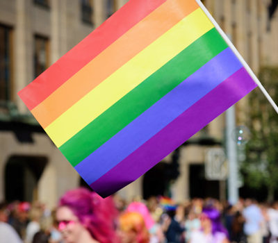 A pride flag being held up at an event.