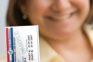 A woman holds up a Medicare card