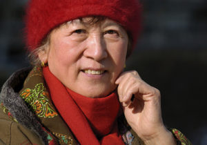 A woman smiling wearing a red hat