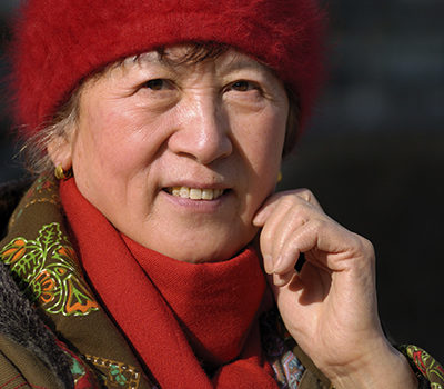 A woman smiling wearing a red hat