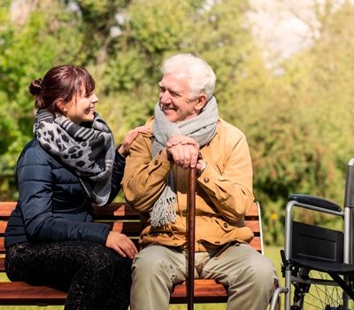 An elderly man and woman sitting on a park bench