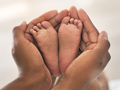 A pair of hands holding a pair of baby feet