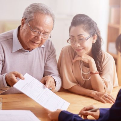 An older couple reviewing documents with a consultant