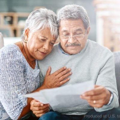 An older couple sitting on a coach and reviewing documents
