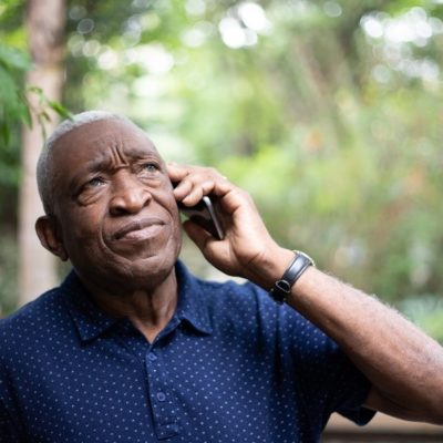 An elderly man talking on a mobile phone.