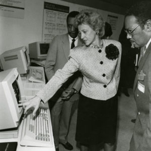 A photo of Dorcas Hardy and two gentlemen looking at a computer monitor.