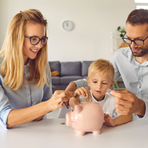 Young family placing coins in a piggy bank