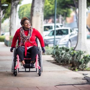 woman in a wheelchair going down a sidewalk