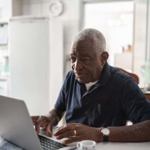 Senior man working at laptop to apply for Social Security benefits