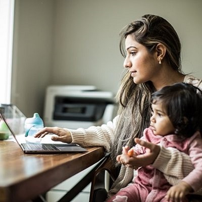 Mother and young child sitting at a desk with a laptop