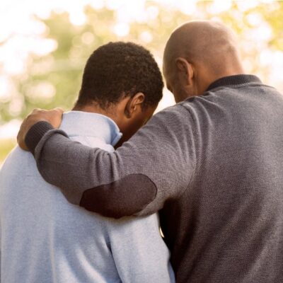Father comforting teenage son